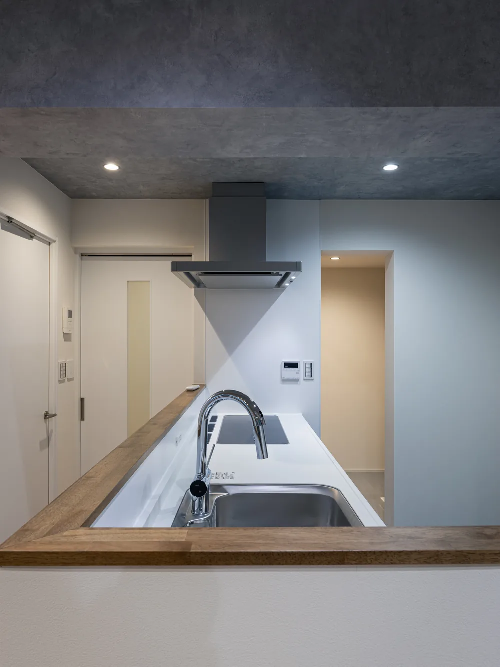 キッチン手元｜コンクリートの天井と、グレーのキッチン（大田区のマンションフルリノベーション事例）