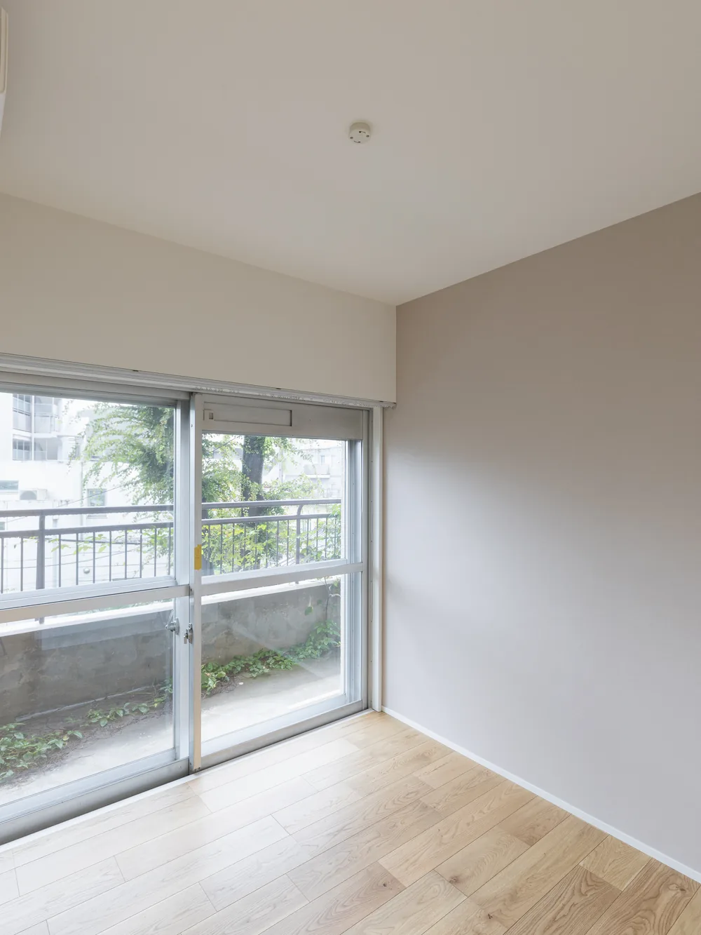 洋室｜コンクリートの天井と、グレーのキッチン（大田区のマンションフルリノベーション事例）