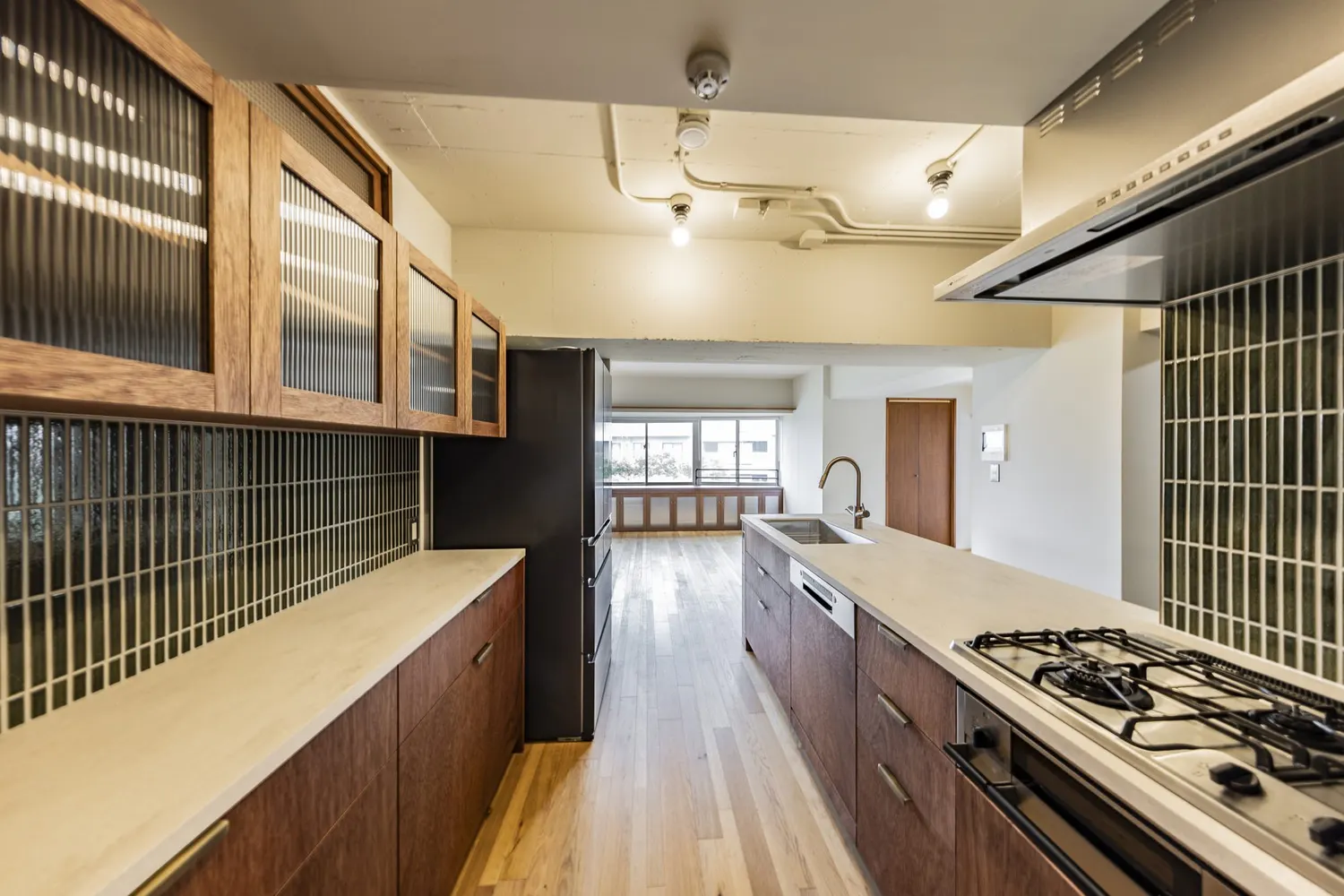 キッチンからLD｜無垢の床と、グリーンタイルのキッチン（稲城市のマンション部分リノベーション事例）