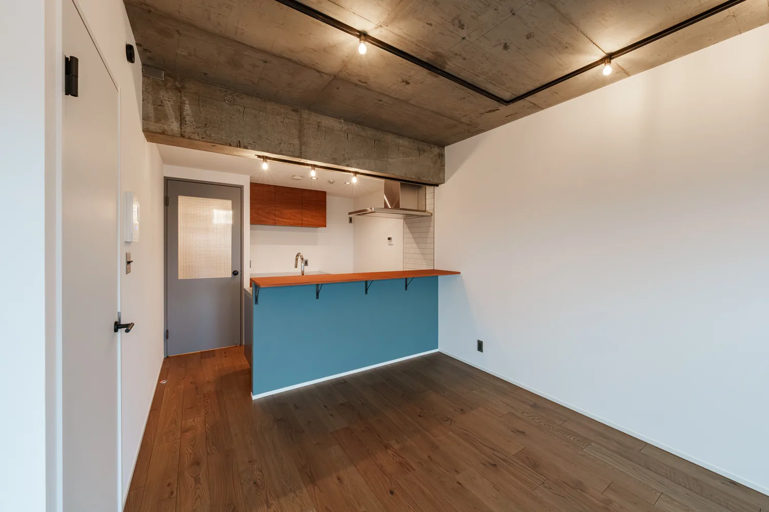 キッチン腰壁｜水色の腰壁と、黒枠の室内窓（杉並区のマンションフルリノベーション事例）
